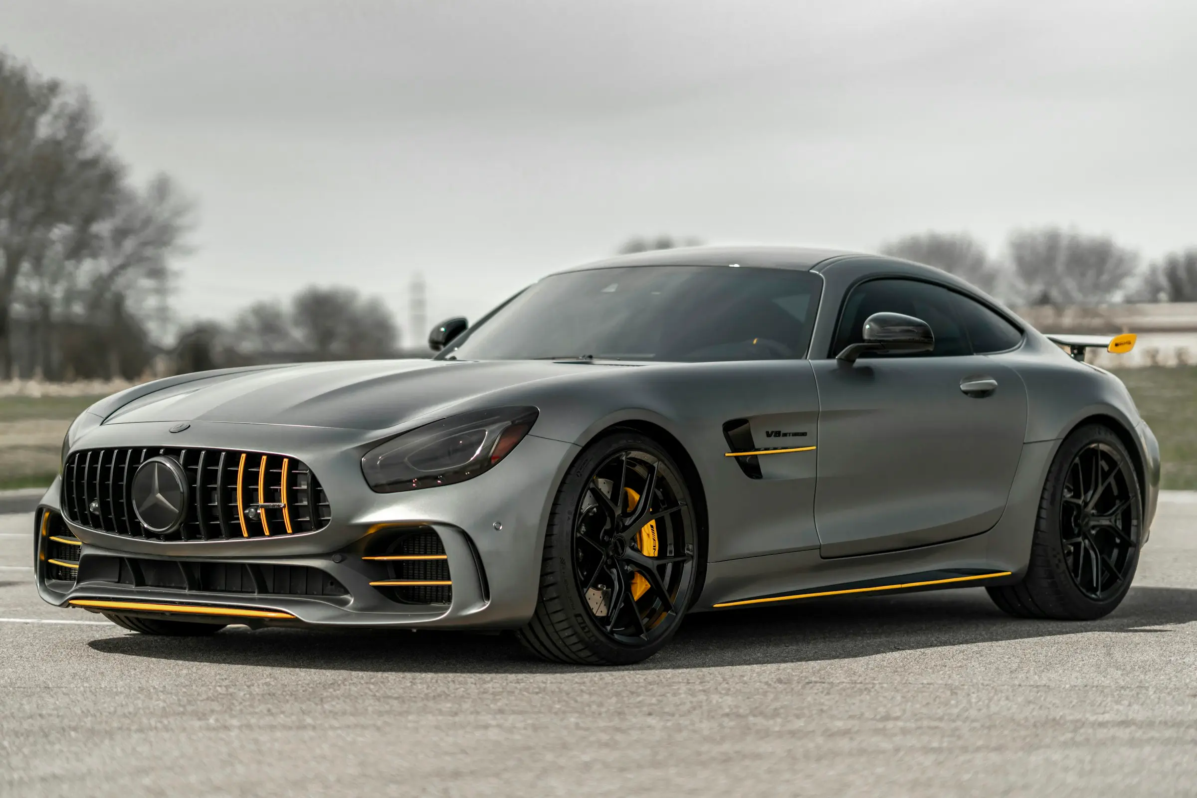 Grey Mercedes-AMG GT R with gold accents on an overcast day