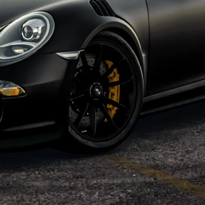 Black wheel with a yellow brake caliper on a Porsche 911